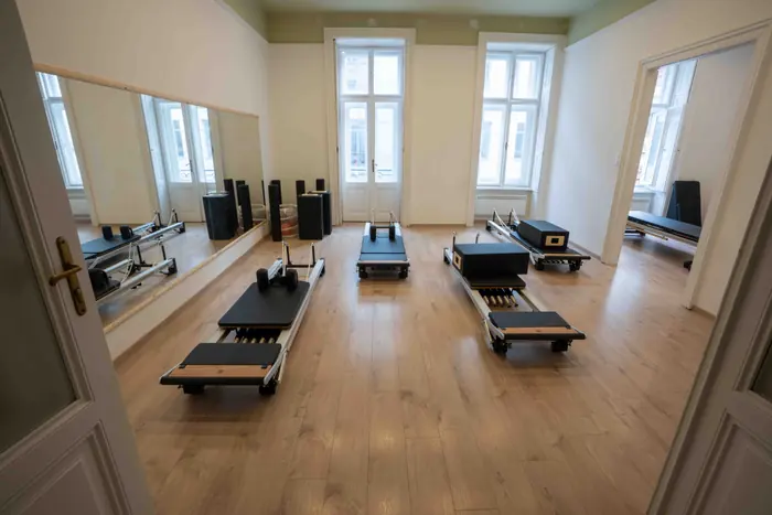A BodyStudy stúdió belső tere a bejárat felől, sorban álló Pilates reformer gépekkel.
